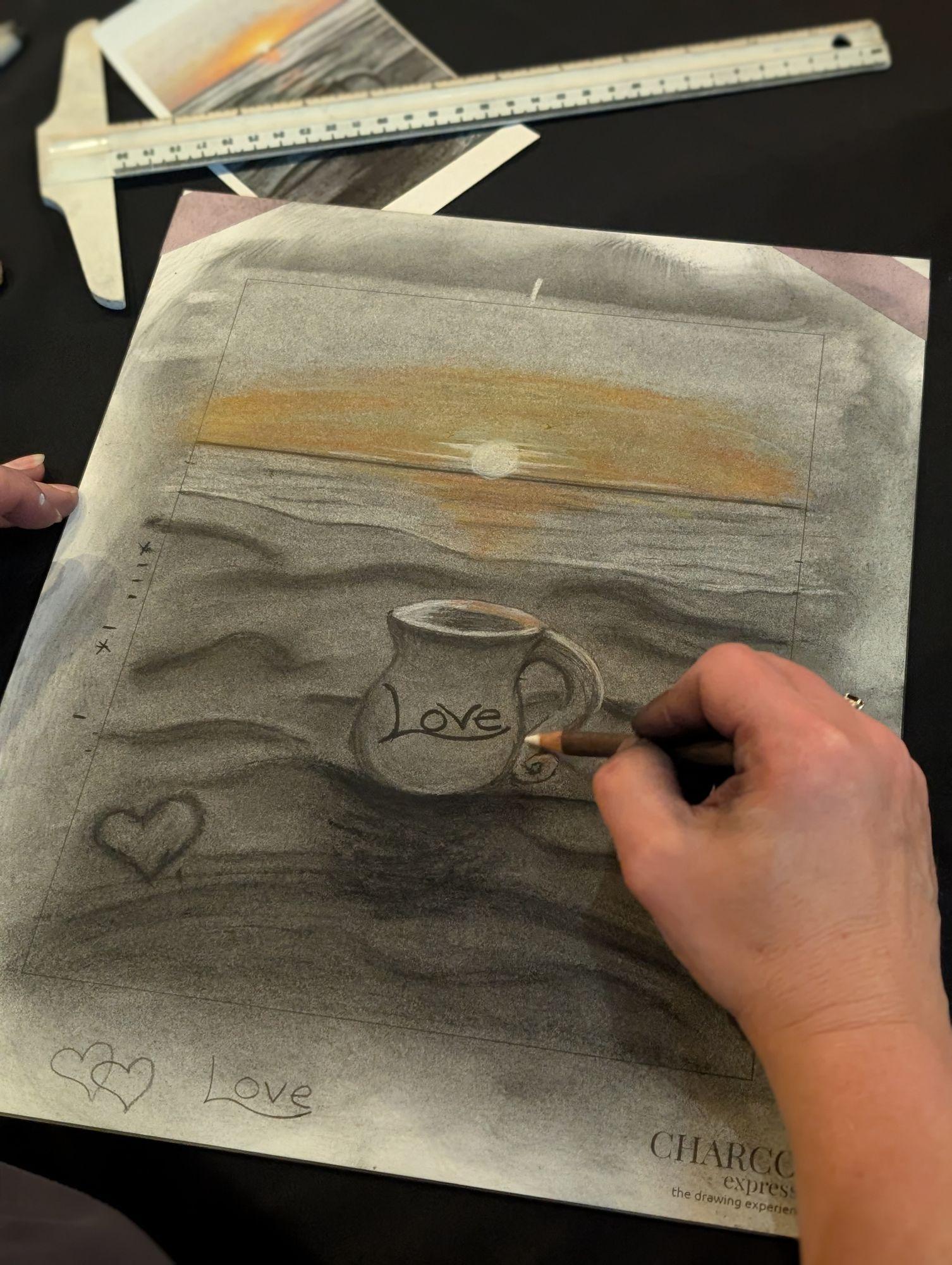 A hand adding charcoal detail to a drawing on a plexiglass-mounted sheet