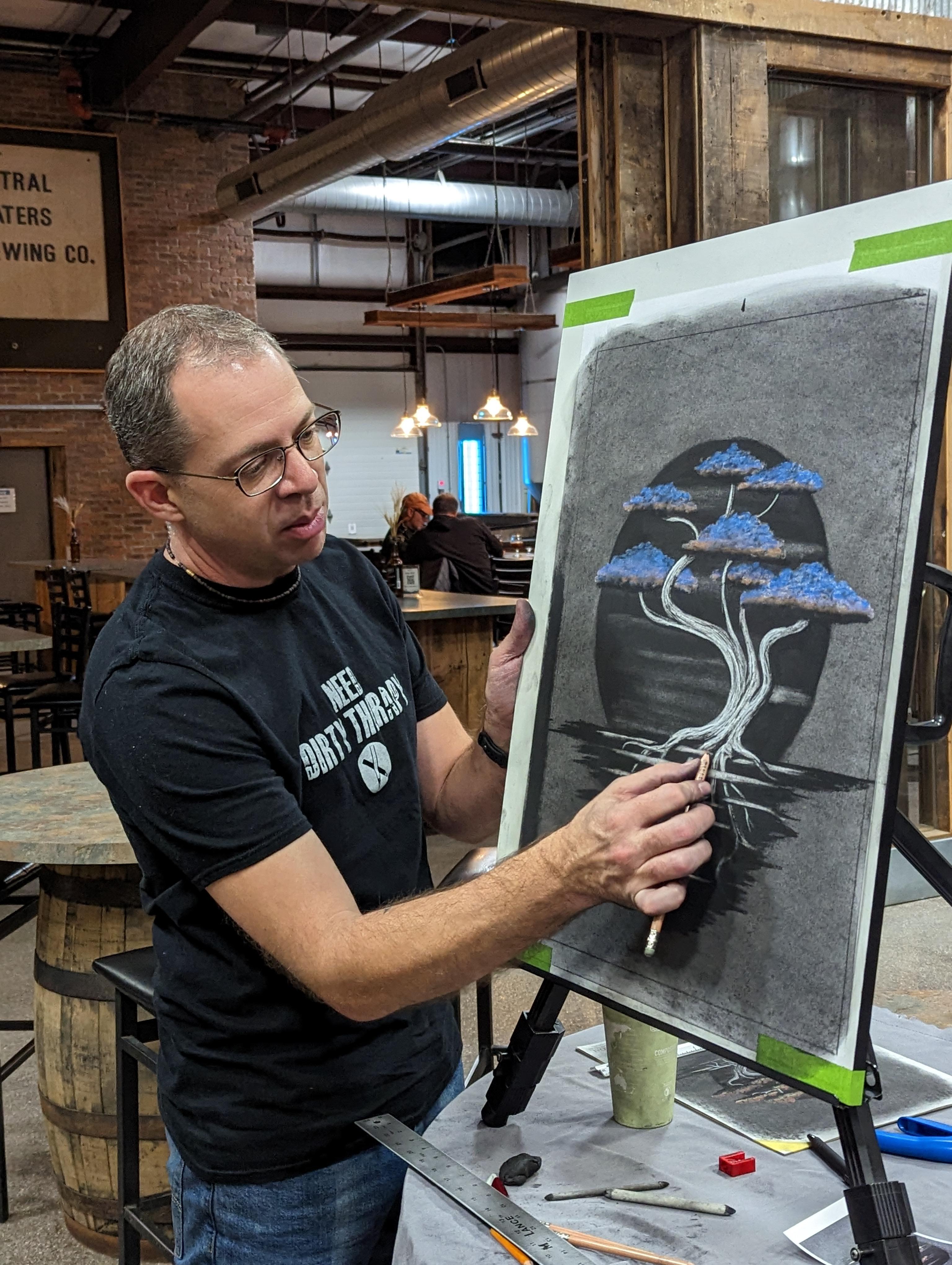 Charcoal Expressions founder creating a bonsai tree charcoal drawing at a live event
